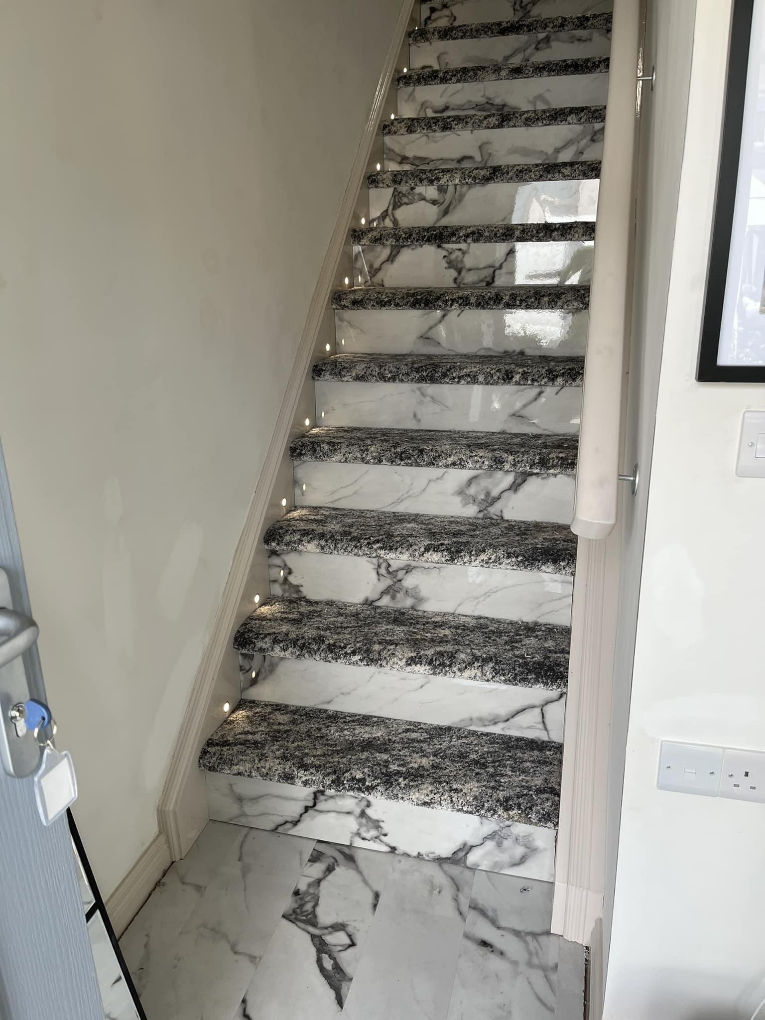 Marble effect laminate floor on stairs with grey carpet